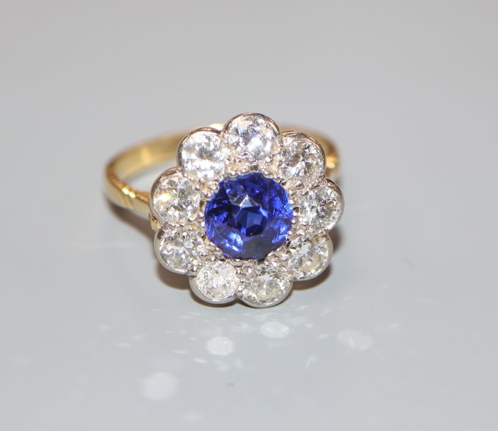 A modern 18ct gold, synthetic sapphire? and diamond circular cluster ring, size P, gross 4.7 grams.